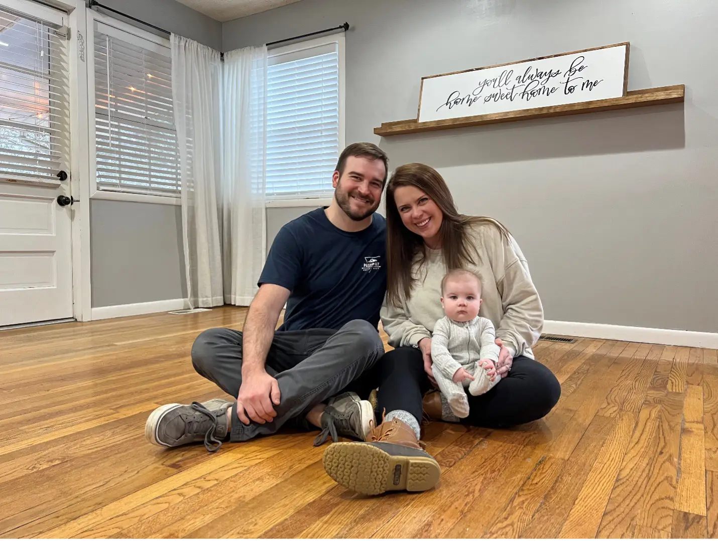 Young family sitting on living room floor Young family sitting on living room floor