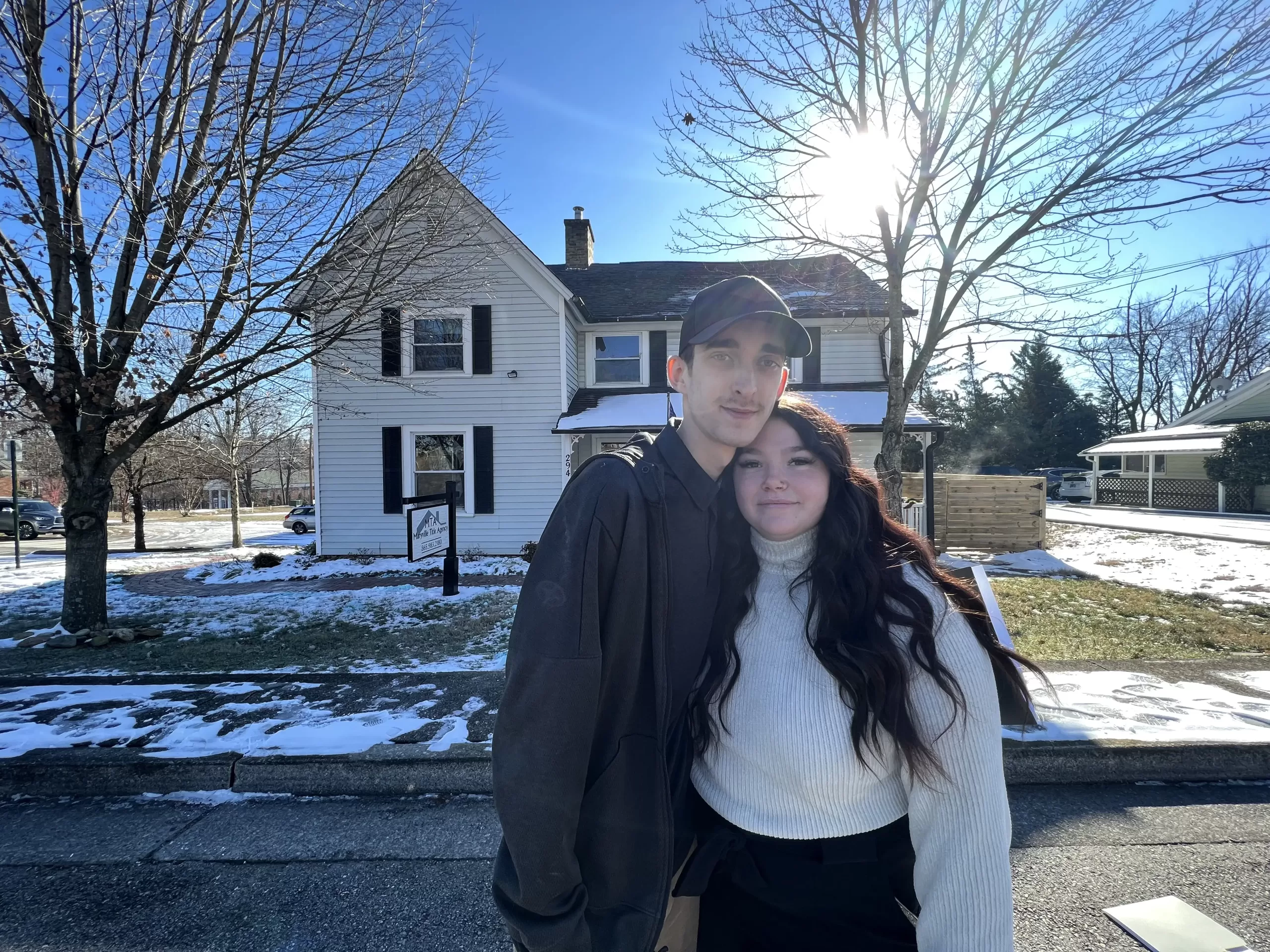 Young-Couple-White-House Young couple standing in front of a house that is for sale